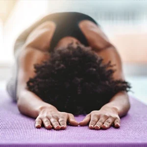 A woman on a yoga mat stretching