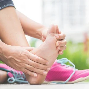 A runner holding their foot in pain